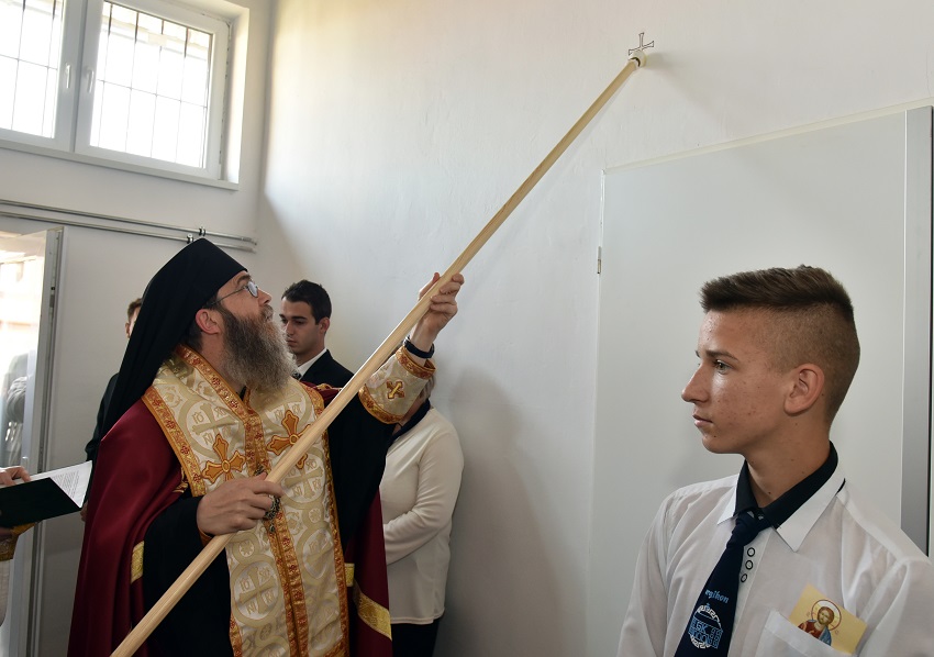Atanáz püspök olajjal keni meg az épület falát