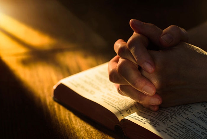 imádkozó kéz a Biblián