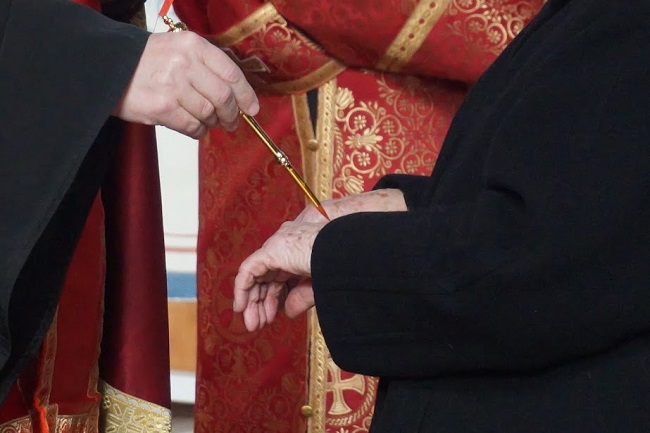 Atanáz püspök olajjal keni meg a kézfejet