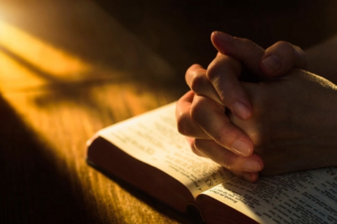 imádkozó kéz a Biblián