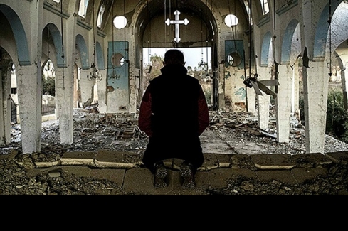 térdepelve imádkozó egy lerombolt templomban