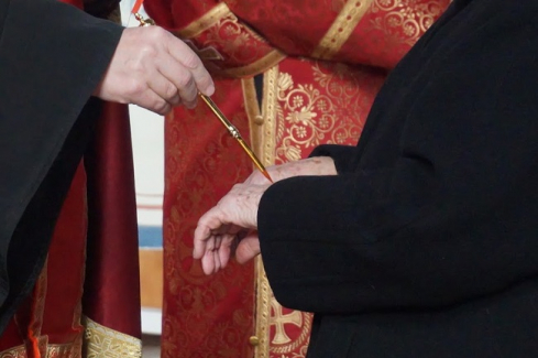 Atanáz püspök olajjal keni meg a kézfejet